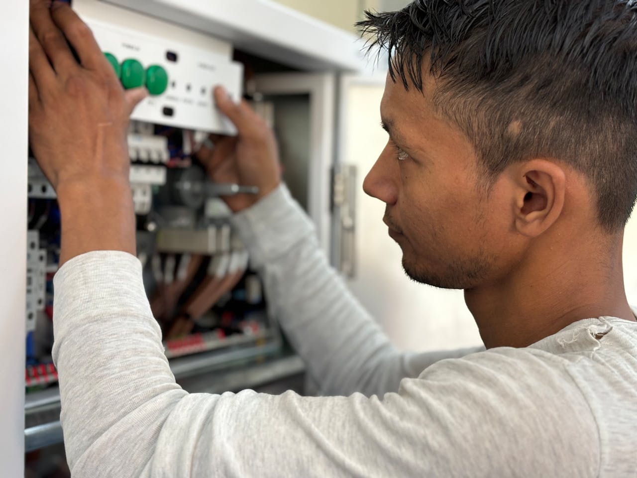 our-story Focused electrician adjusting circuit breaker panel. Technology and skill in action.