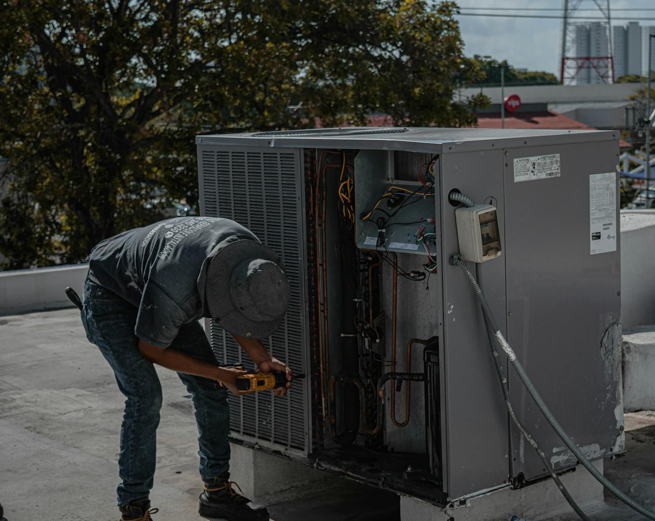 The Art of Drawing Readers In: Your attractive post title goes here A technician is repairing an air conditioning unit on a rooftop, demonstrating skilled manual work.
