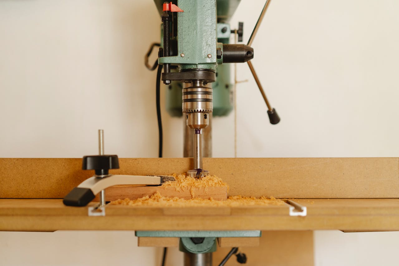 creative-02 Professional drill machine for cutting wooden details near white wall in modern workshop